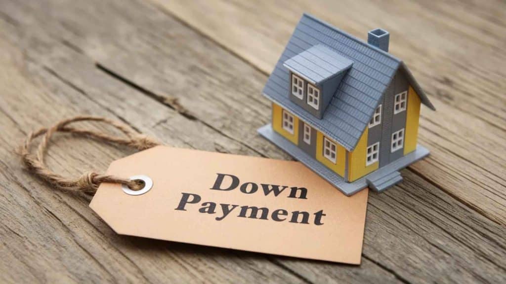 A model house with a Down Payment tag placed on a wooden surface.