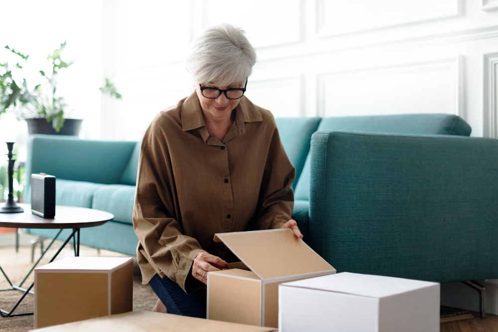 elderly woman packing boxes for downsizing to a smaller home.
