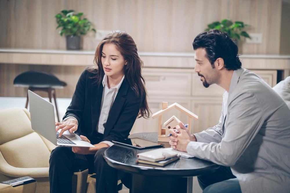 professional discussing further advanced mortgage options with a client, using a laptop.