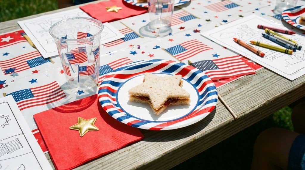 A Memorial Day kids' table setting with red napkin and star decoration.