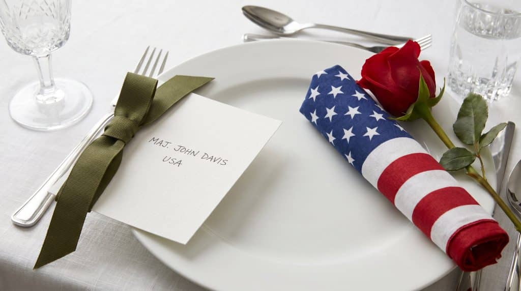 A Memorial Day place setting with service branch ribbons for tribute.