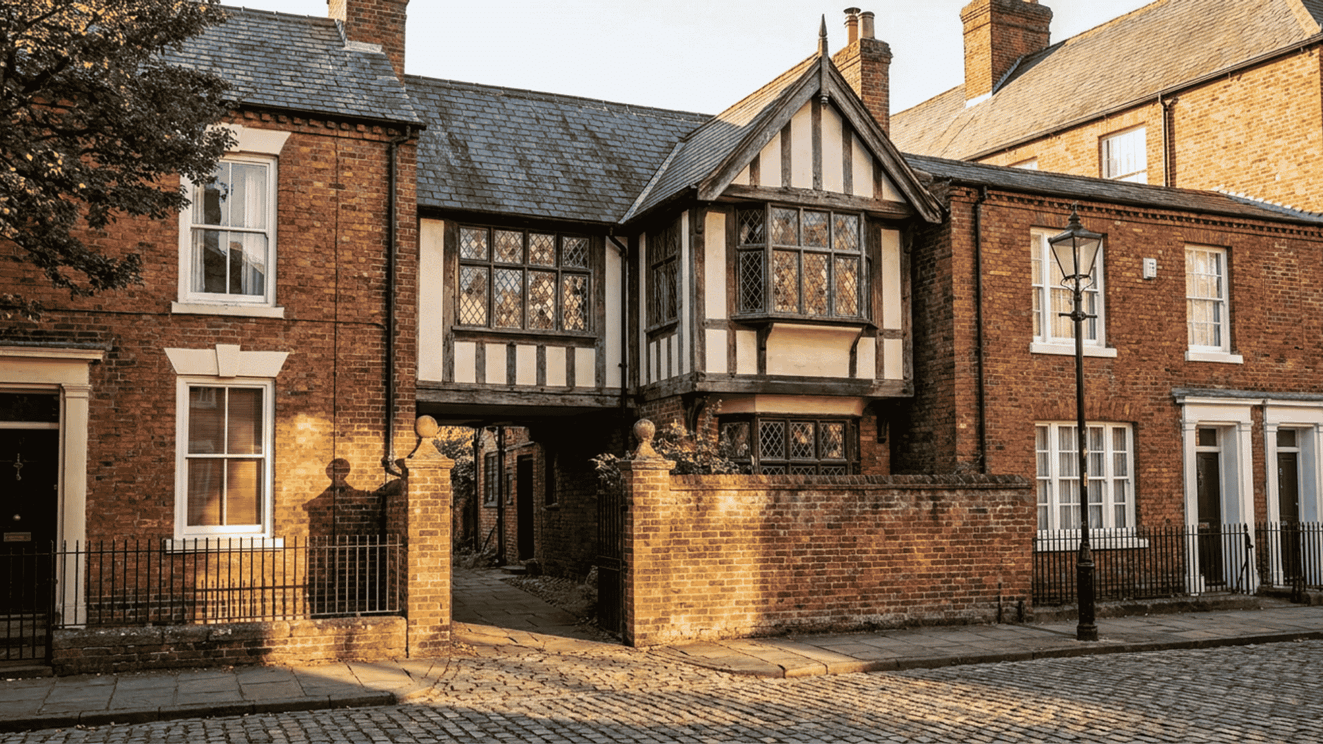 Traditional brick and half-timbered cottages on a cobblestone street, showing a flying freehold structure.