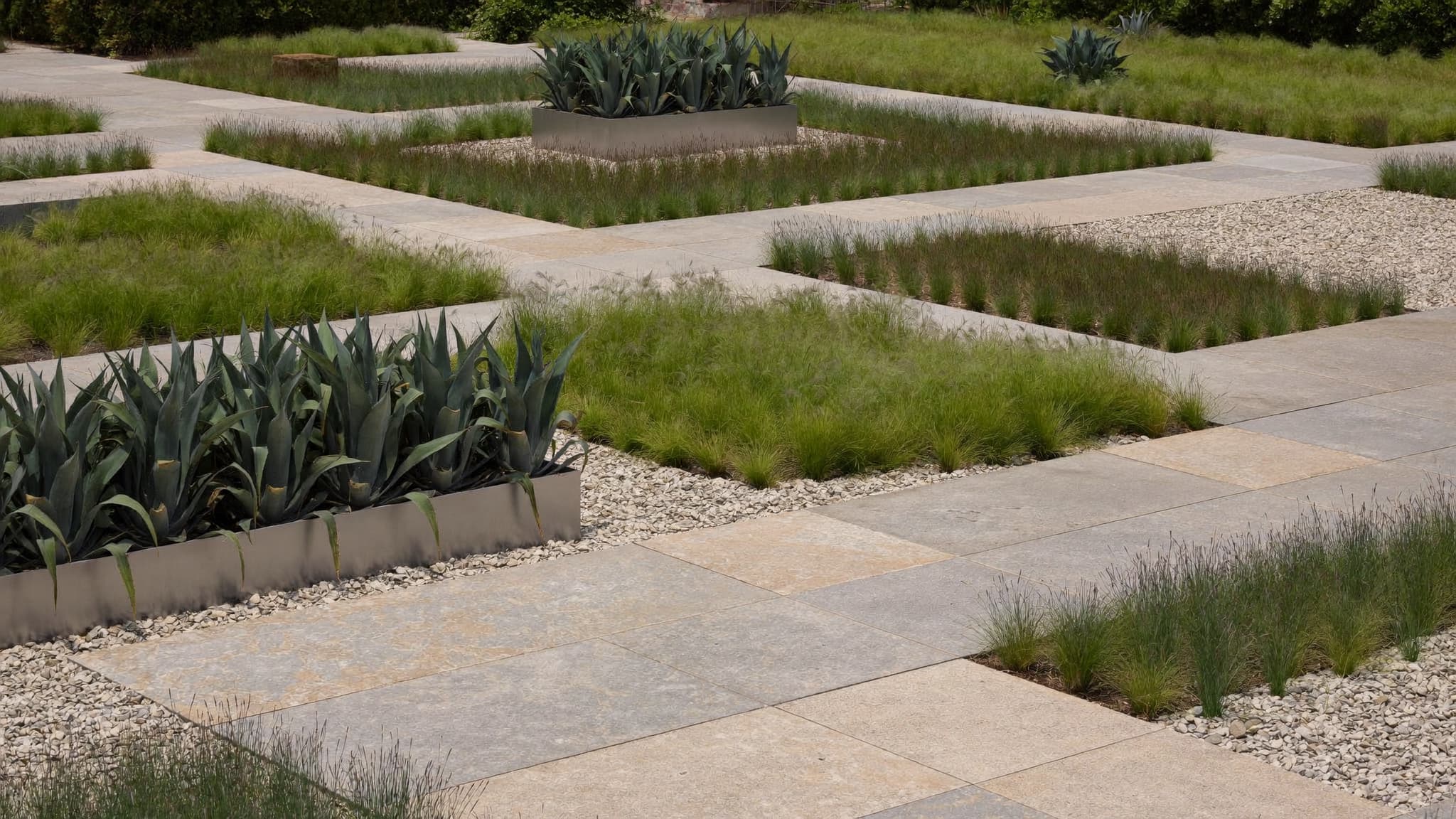 Geometric garden layout with stone walkways, ornamental grasses, and modern landscaping design.