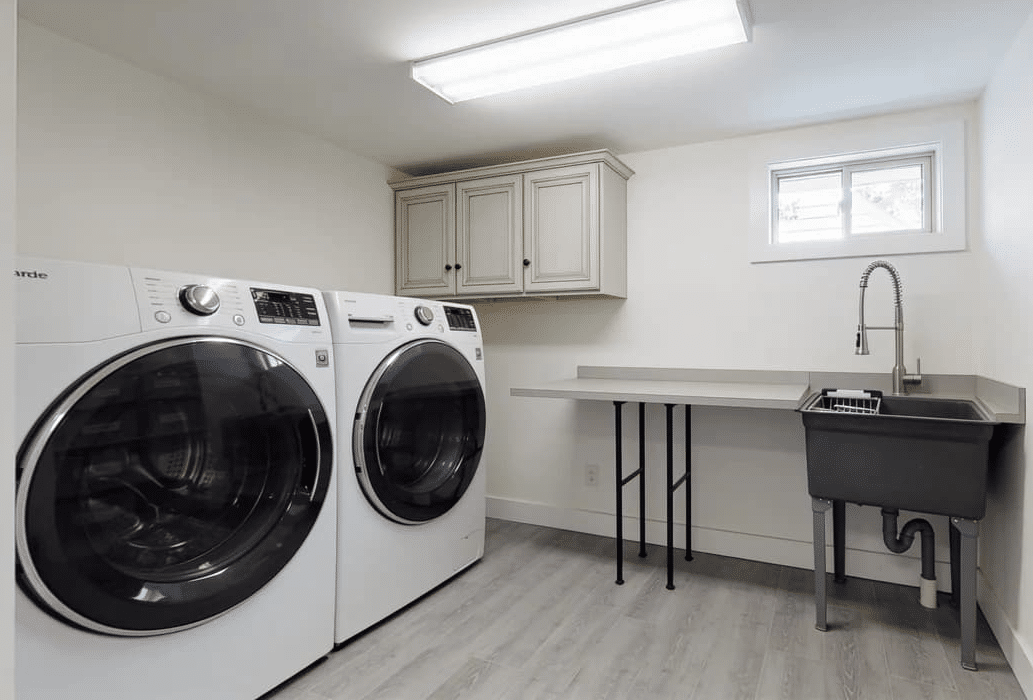 Laundry room addition with cabinets and utility storage.